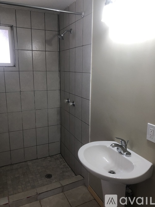 A bathroom with a white sink and a tiled shower.