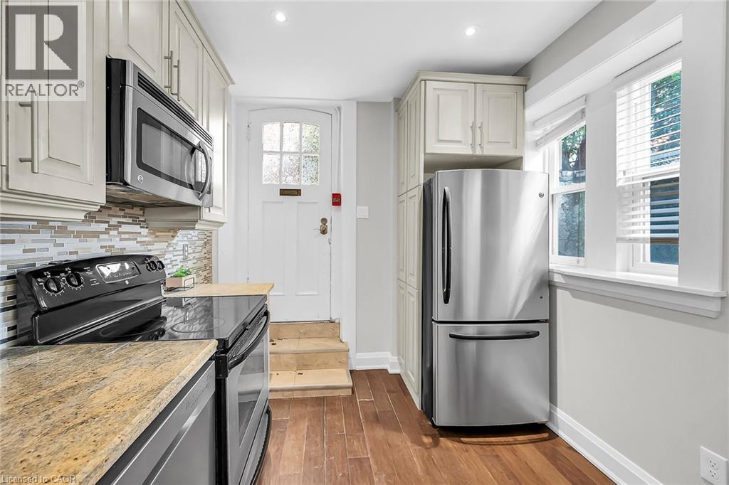 A kitchen with a stainless steel refrigerator and a stone countertop.