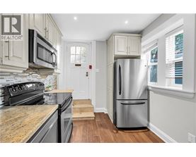 A kitchen with a stainless steel refrigerator and a stone countertop.