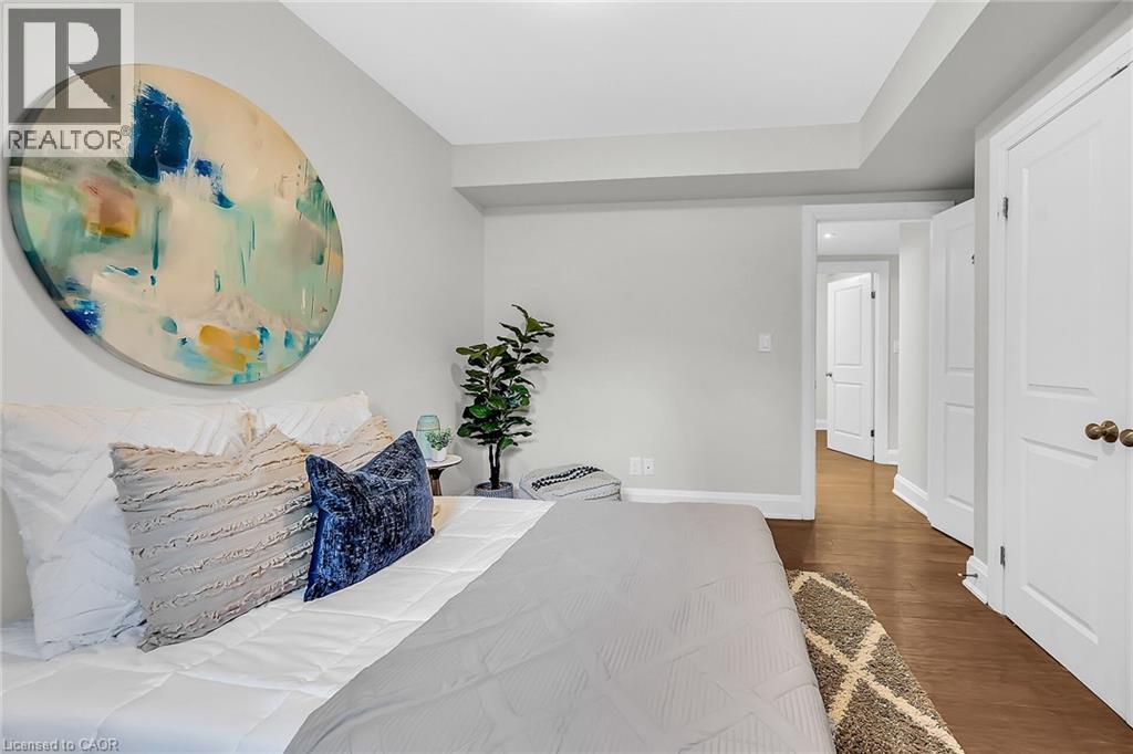 A bedroom with a large bed and a painting on the wall.