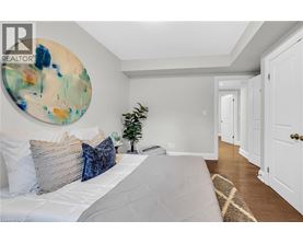A bedroom with a large bed and a painting on the wall.