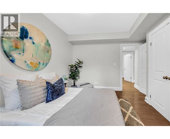 A bedroom with a large bed and a painting on the wall.