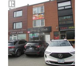 A white car is parked in front of a building with a sign that says "Savage & Nails.".