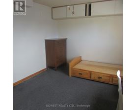 A bedroom with a bed, dresser and wardrobe.