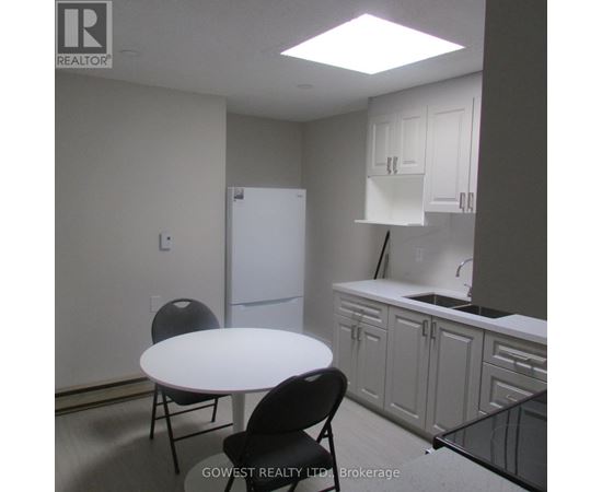 A kitchen with white cabinets and a white table.