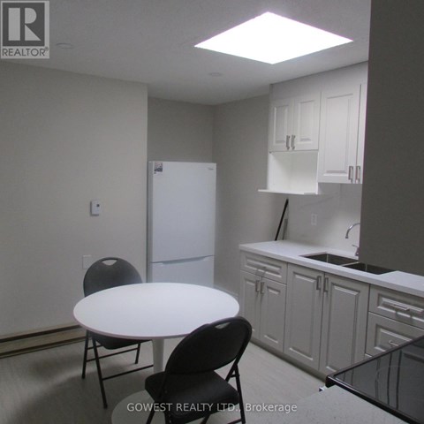 A kitchen with white cabinets and a white table.