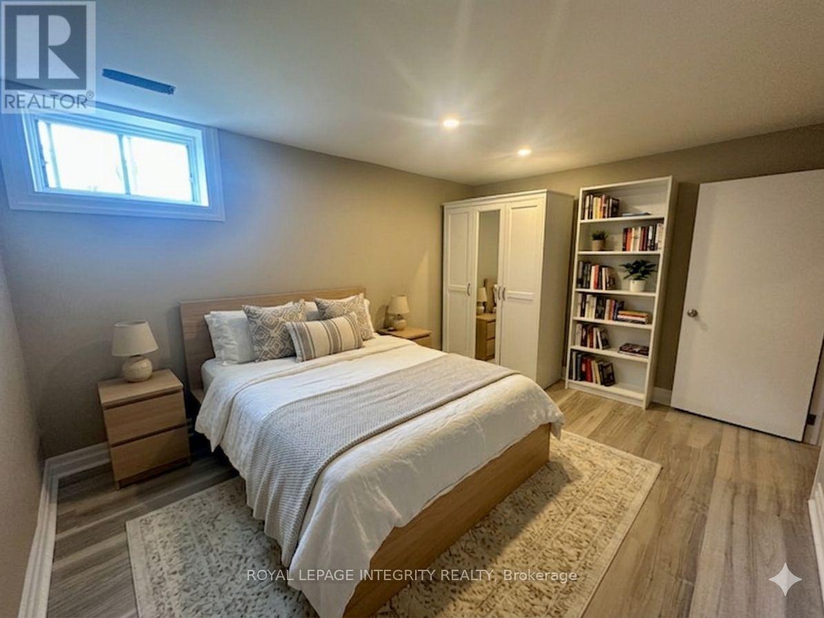 A bedroom with a bed, nightstand, and mirror.