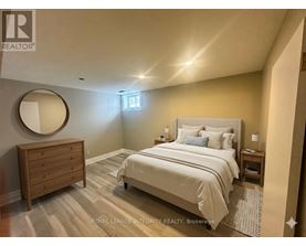 A bedroom with a bed, nightstand, and mirror.