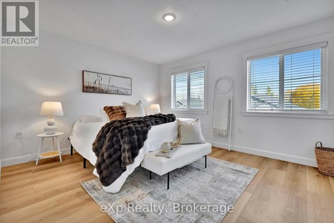 A living room with a white couch and a painting on the wall.