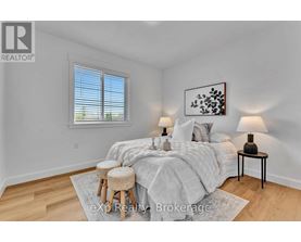 A bedroom with a bed, two lamps, and a painting on the wall.