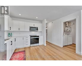 A kitchen with white cabinets and a red rug on the floor.