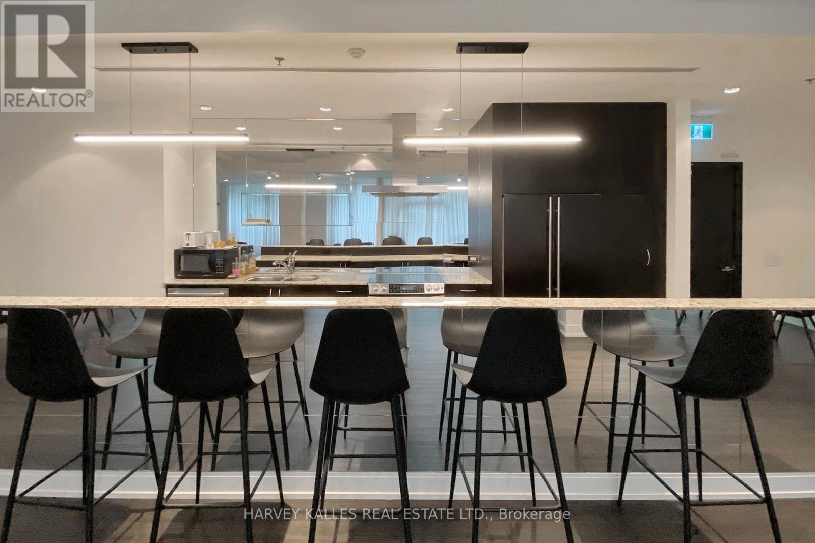 A modern dining area with a long table and black chairs.