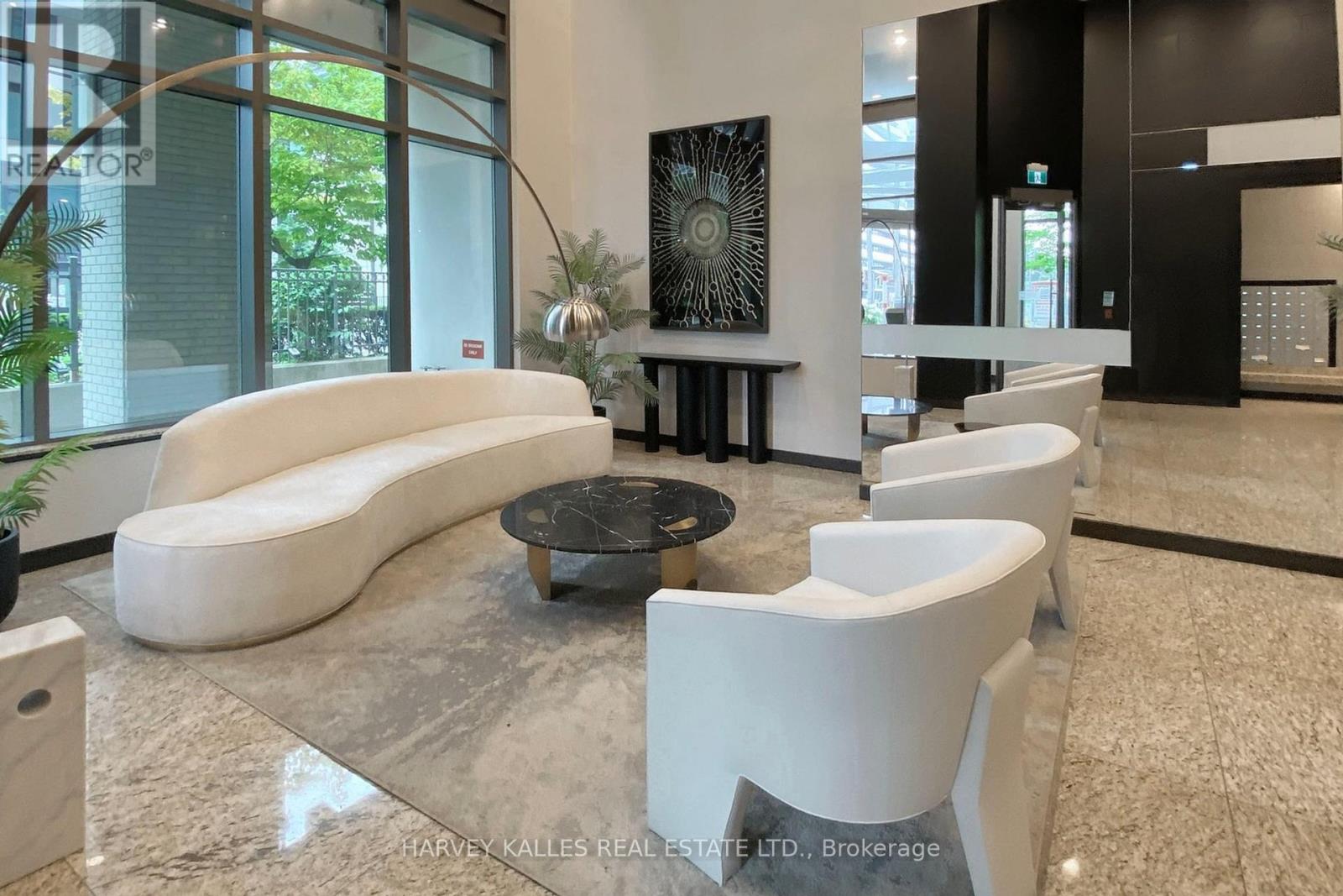 A modern living room with a white sofa and a glass table.