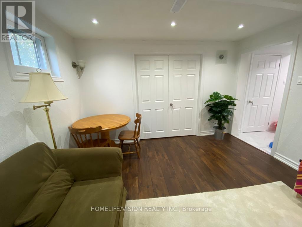 A living room with a brown couch, a round table, and a potted plant.