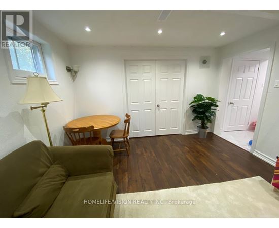 A living room with a brown couch, a round table, and a potted plant.