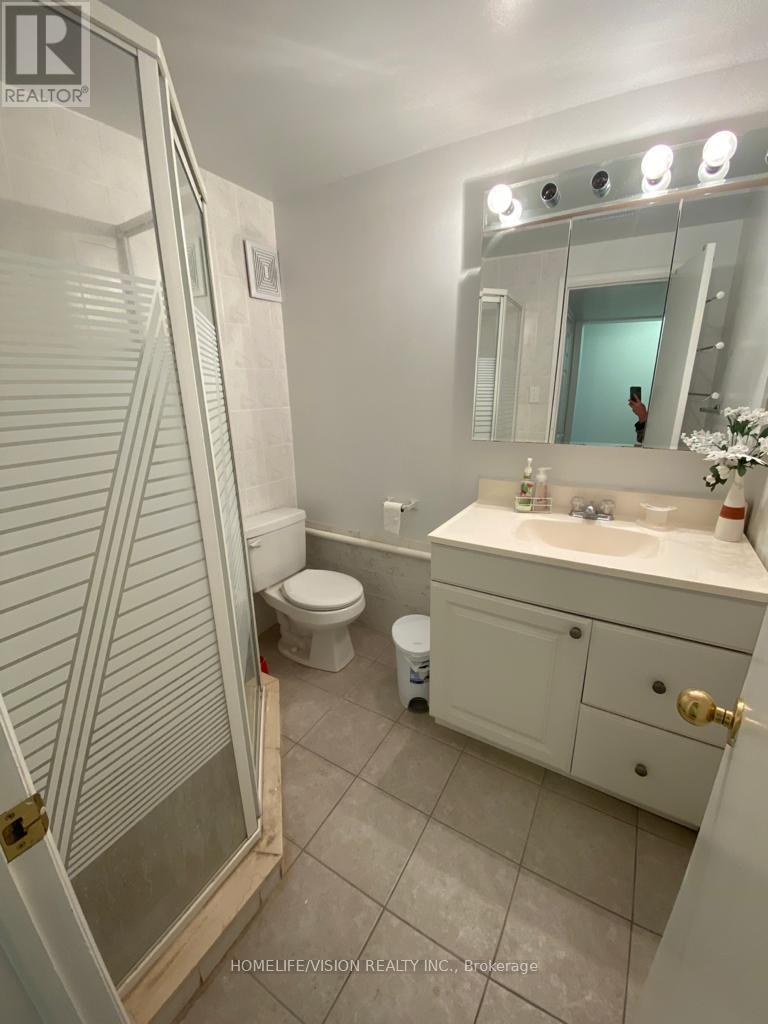 A bathroom with a toilet, sink, and shower.