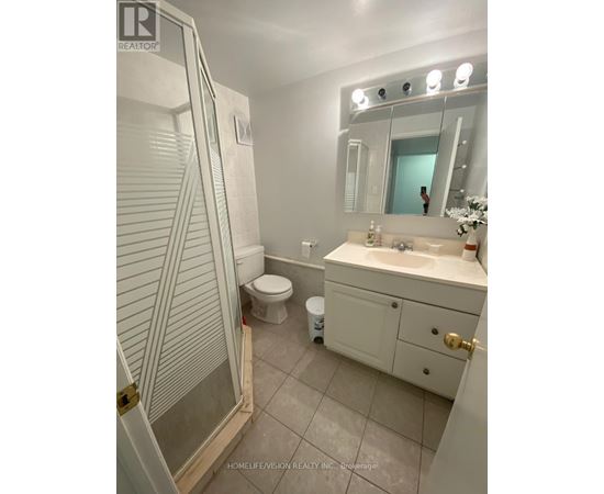 A bathroom with a toilet, sink, and shower.