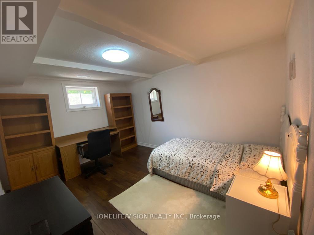 A bedroom with a bed, desk, and chair.