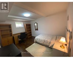 A bedroom with a bed, desk, and chair.