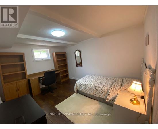 A bedroom with a bed, desk, and chair.