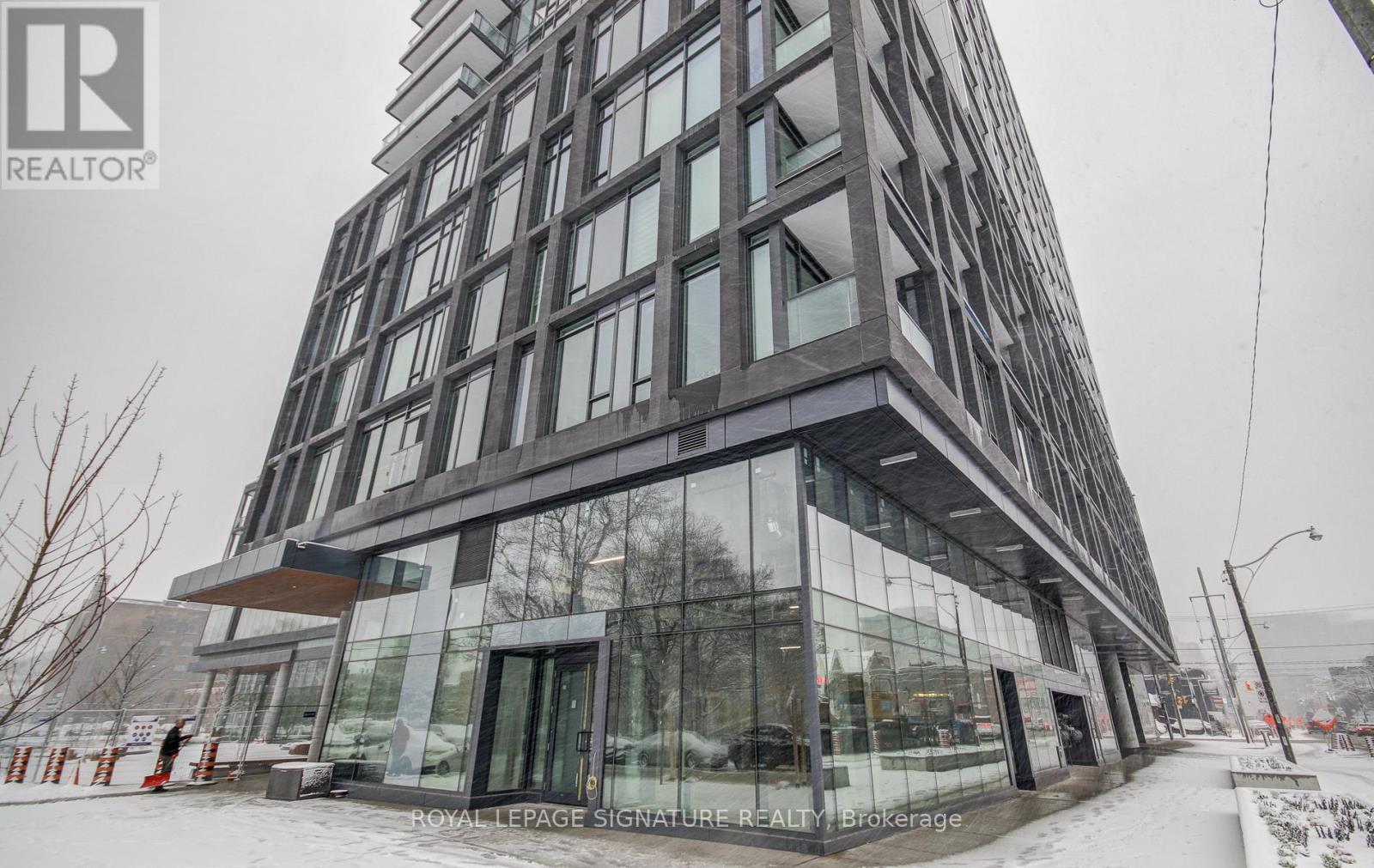 A modern building with a glass facade and a sign that reads "Royal LePage Signature Realty Brokerage.".