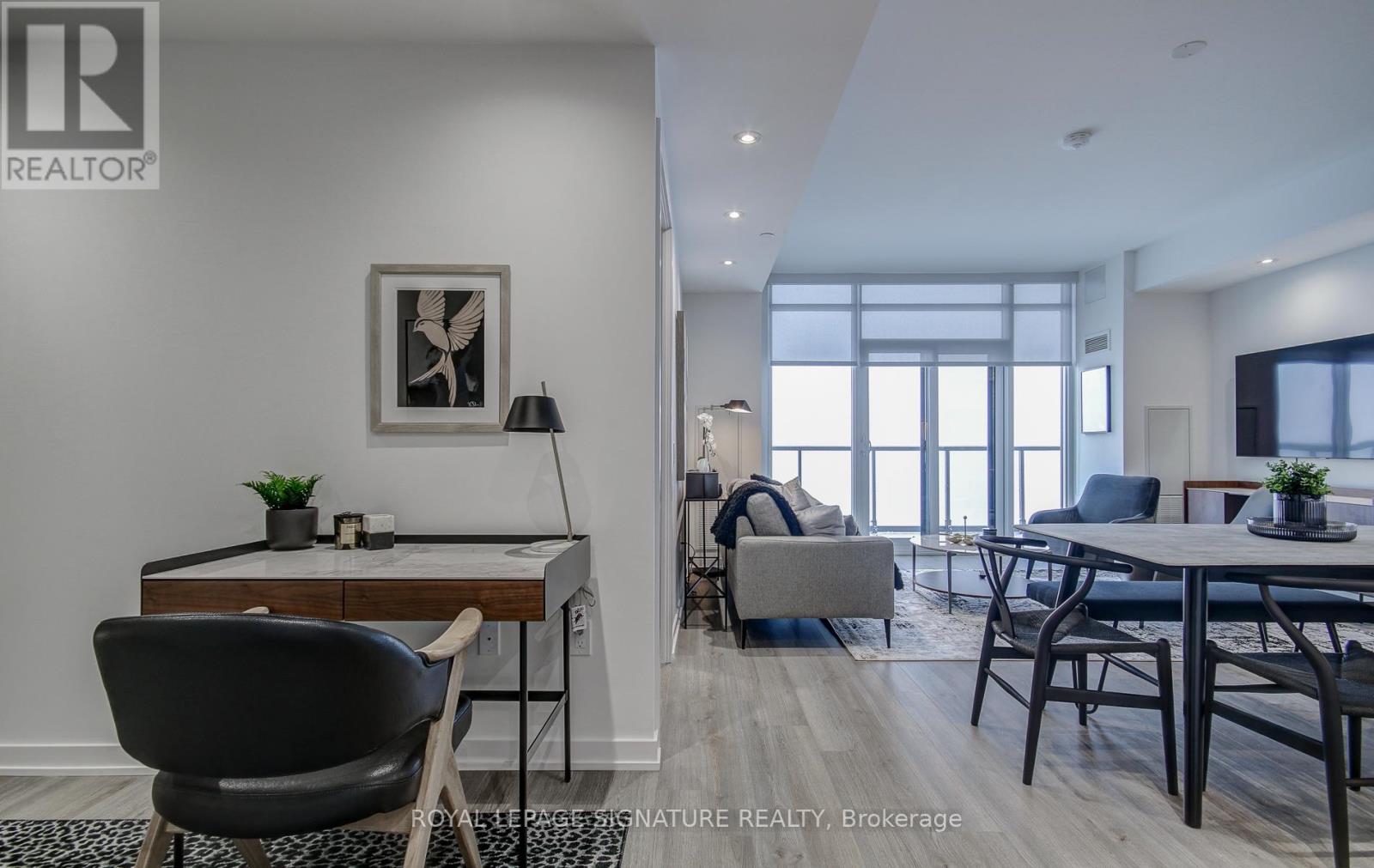 A modern living room with a dining table and chairs.