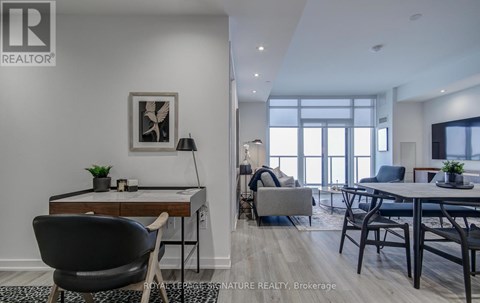 A modern living room with a dining table and chairs.