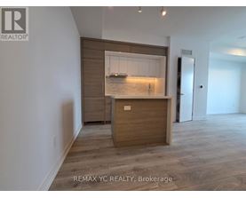 A REALTOR® logo is on the wall above a wooden cabinet with a glass door.