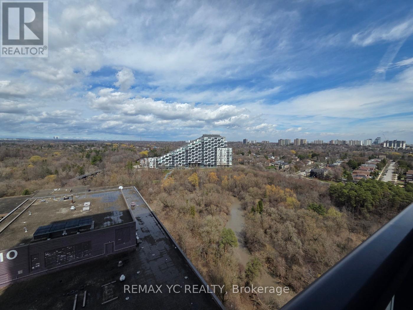 A view from a train window showing a large building and a landscape below.