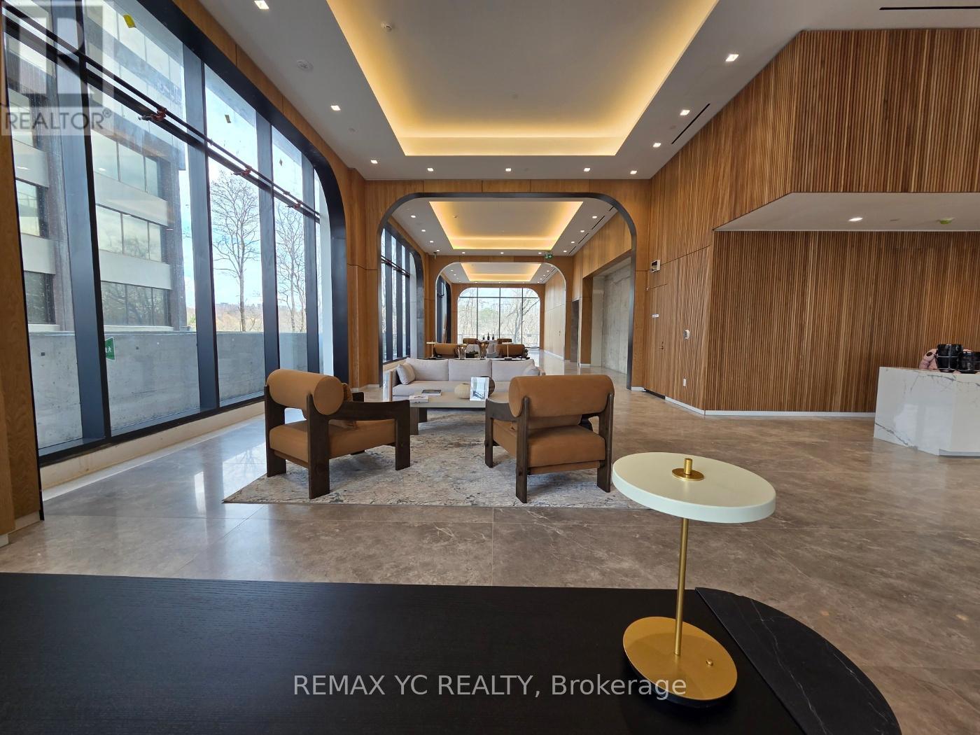 A modern living room with a long wooden wall and a glass door.
