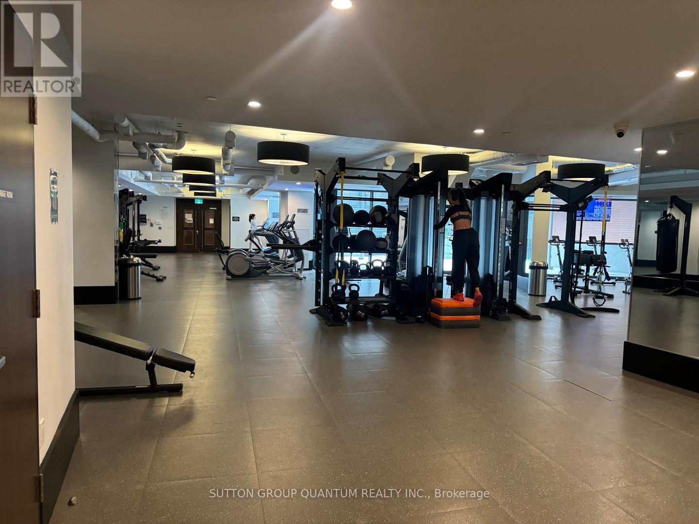 A gym with a variety of equipment including weights and cardio machines.