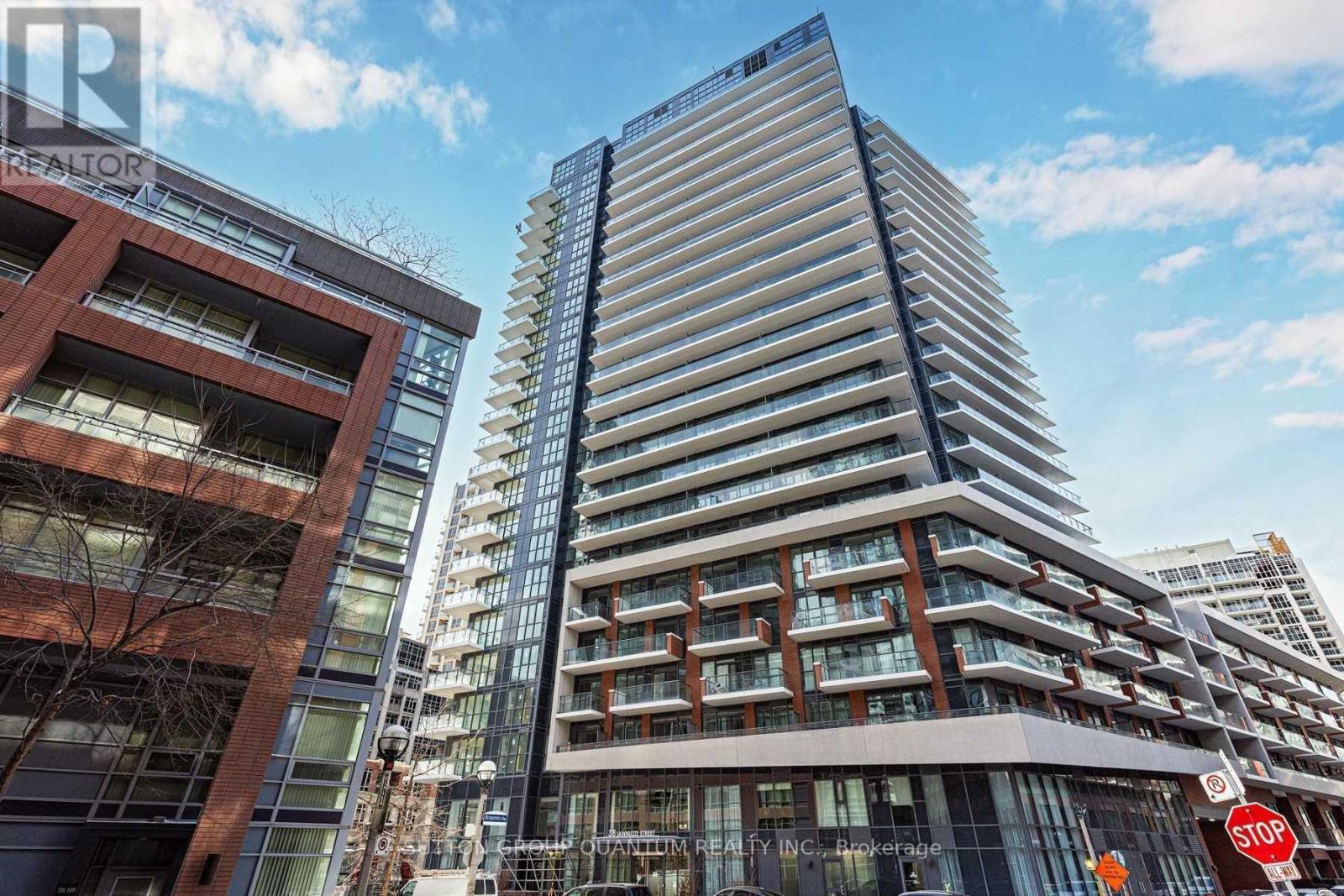 A tall, modern building with a curved facade stands next to a shorter, more traditional building.