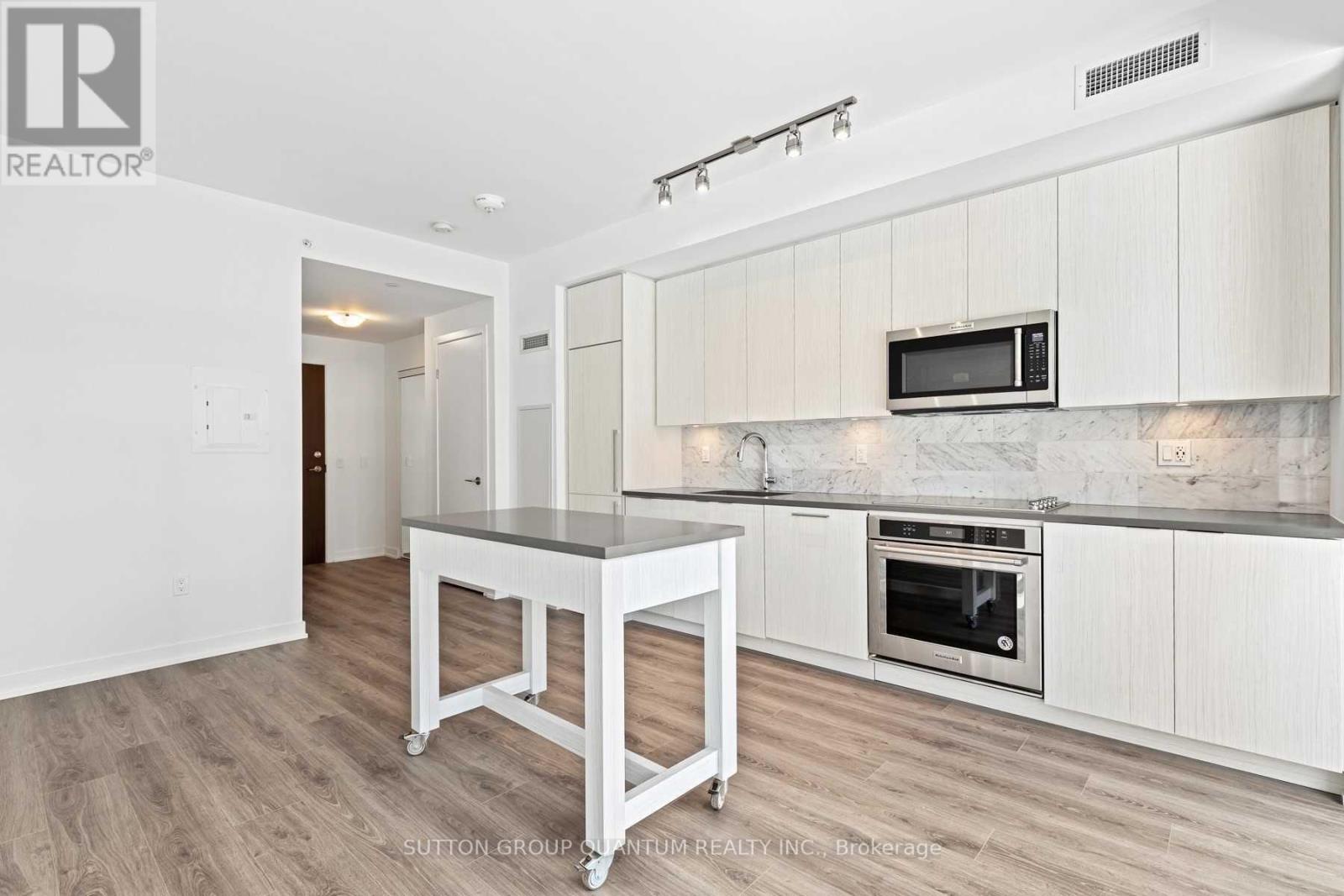 A kitchen with white cabinets and a black countertop.