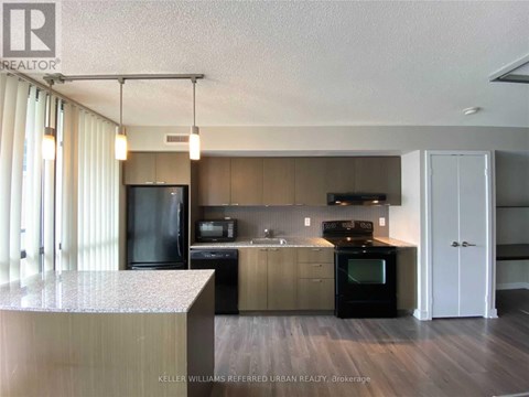 A modern kitchen with a black refrigerator and a black oven.