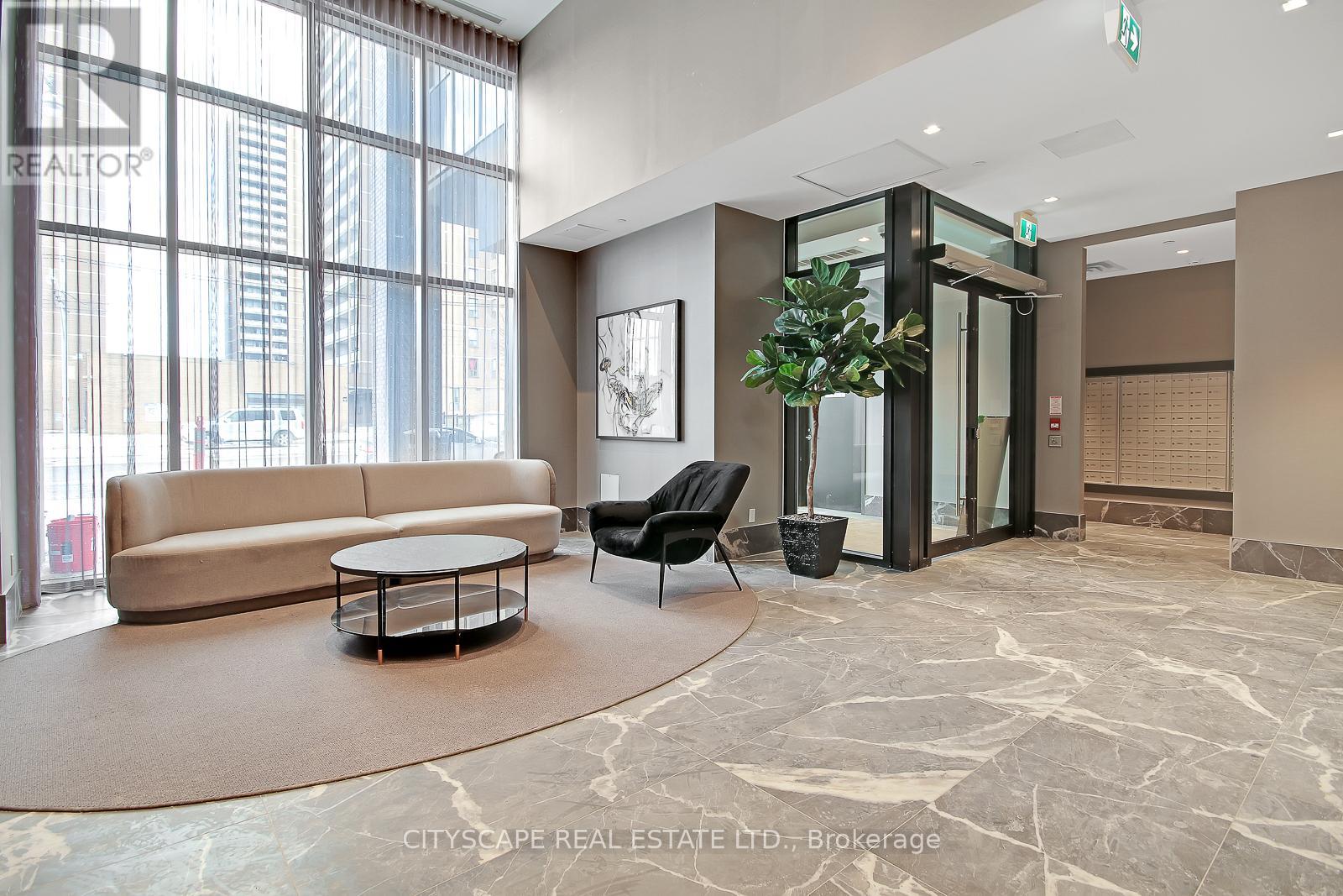 A living room with a couch, chair, and a plant.