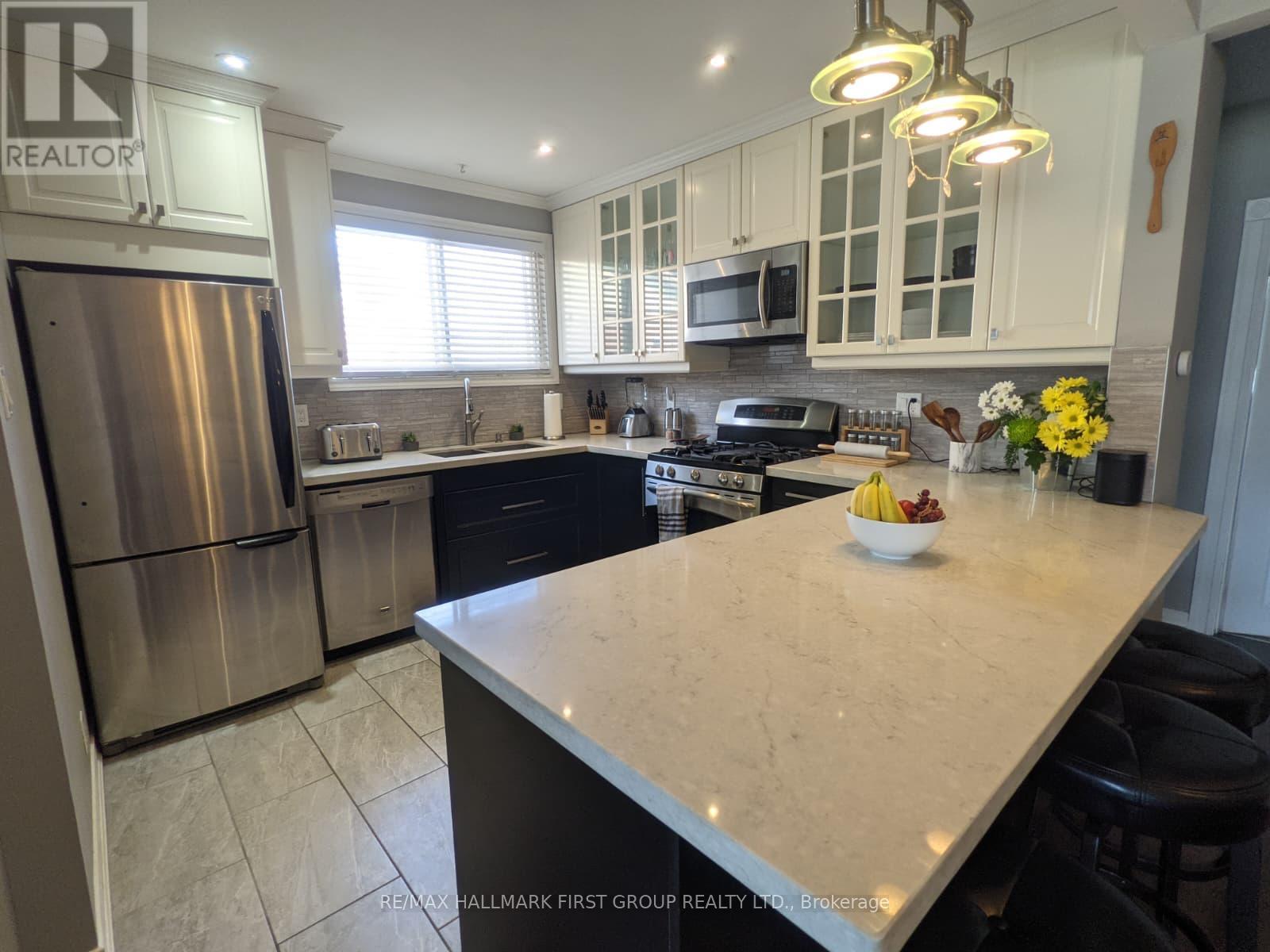 A kitchen with a large island and stainless steel appliances.