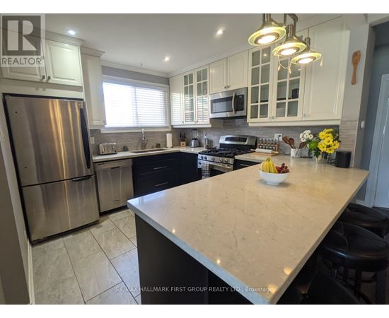 A kitchen with a large island and stainless steel appliances.