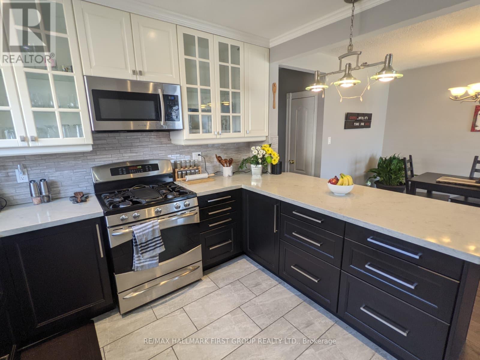 A kitchen with black cabinets and a stove top oven.