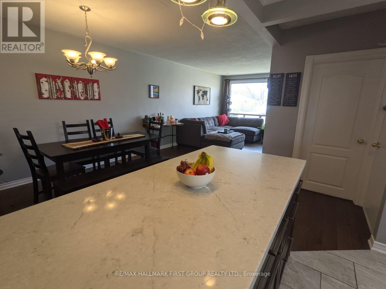 A kitchen with a marble countertop and a bowl of fruit on it.