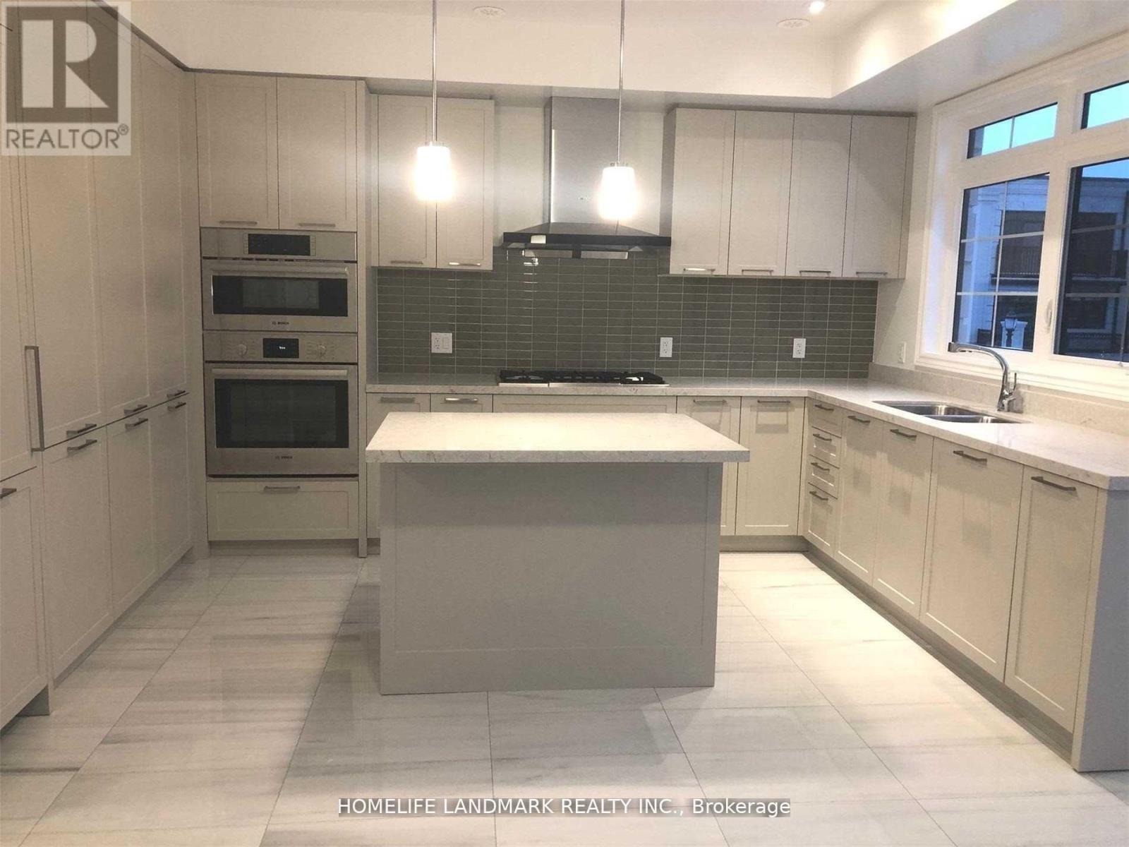 A kitchen with white cabinets and a central island.