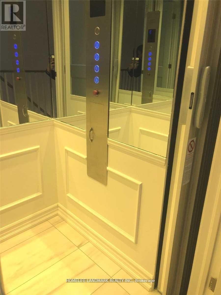 A white elevator with a Realtor sign on the wall.