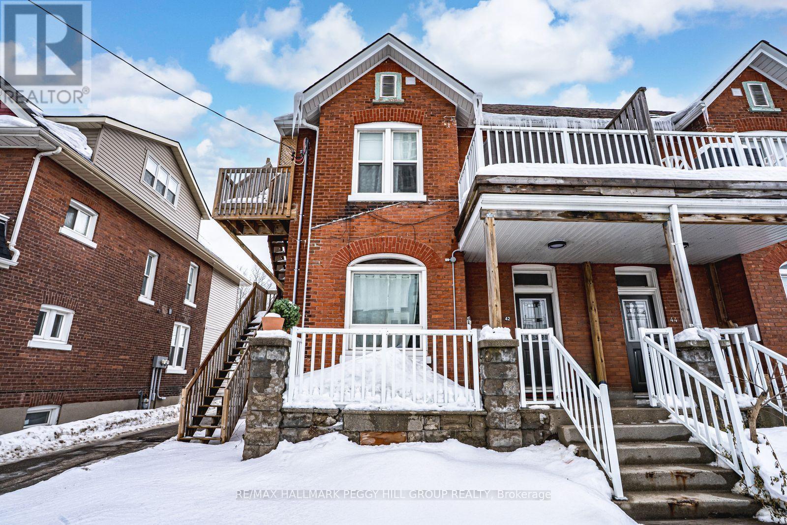 A house with a red brick facade and a white porch.