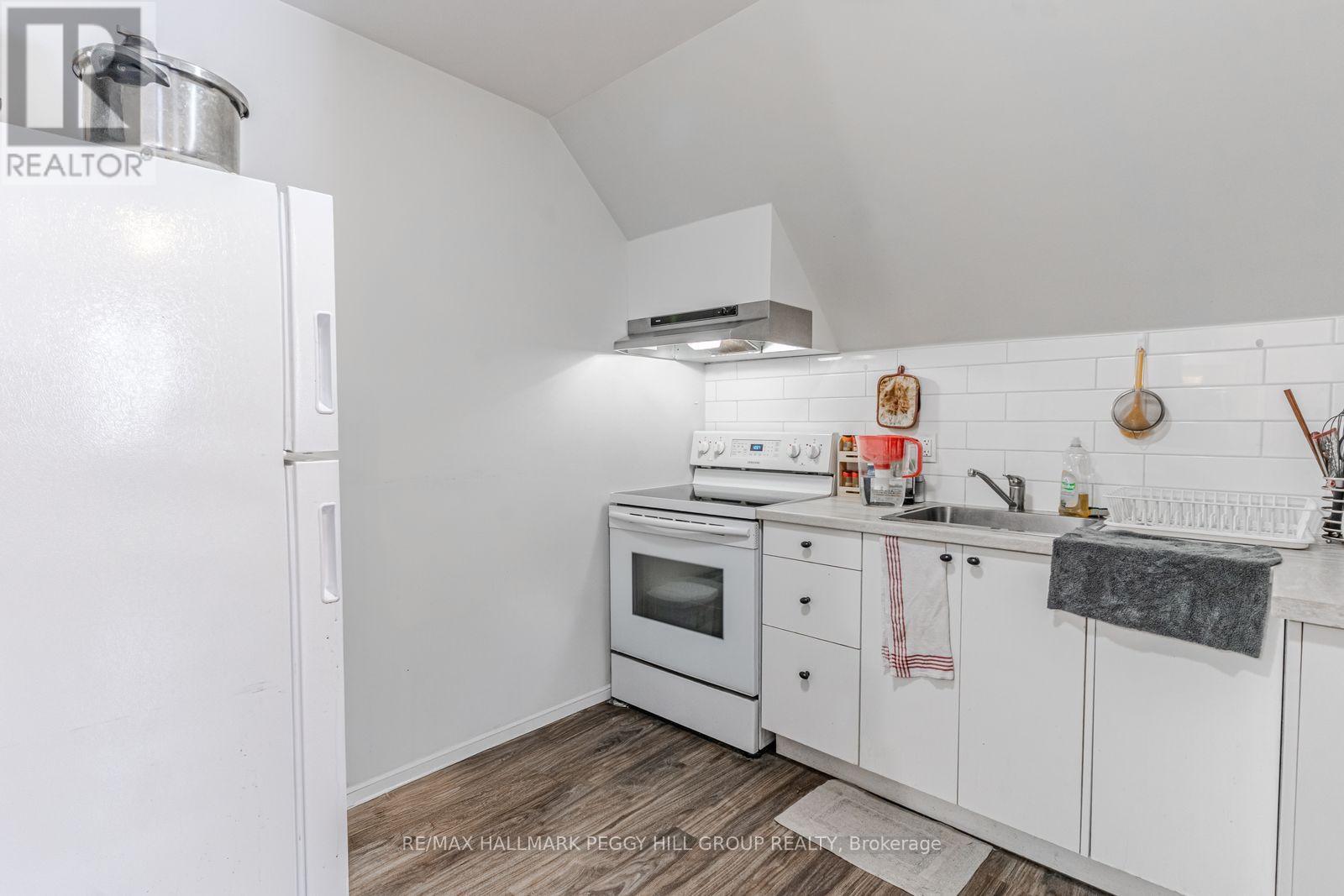 A white kitchen with a refrigerator and oven.