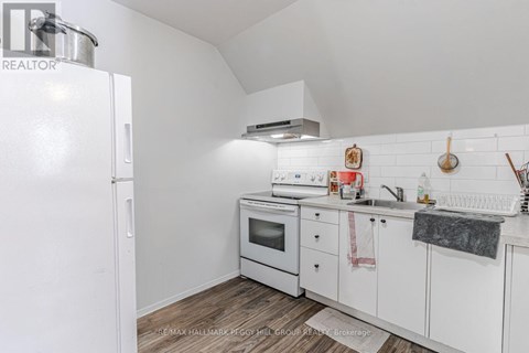 A white kitchen with a refrigerator and oven.