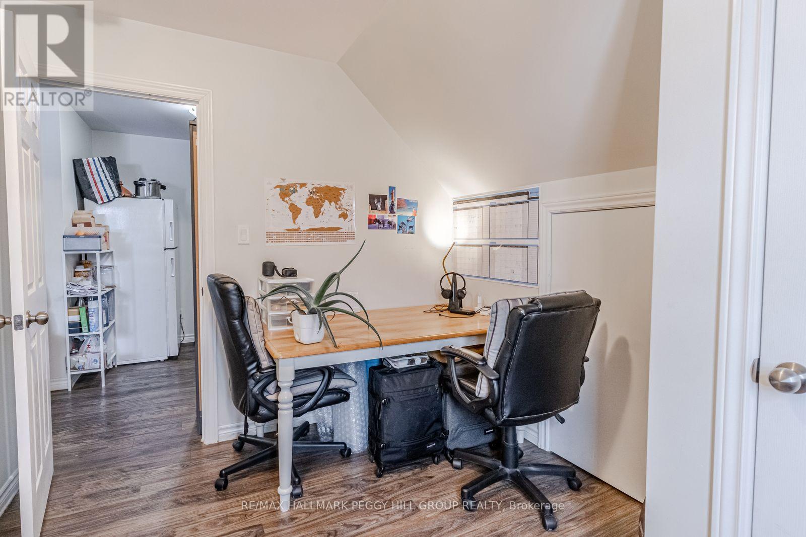 A room with a desk and chairs and a world map on the wall.