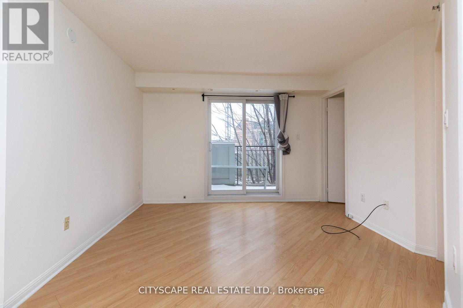 A room with a window and wooden flooring.