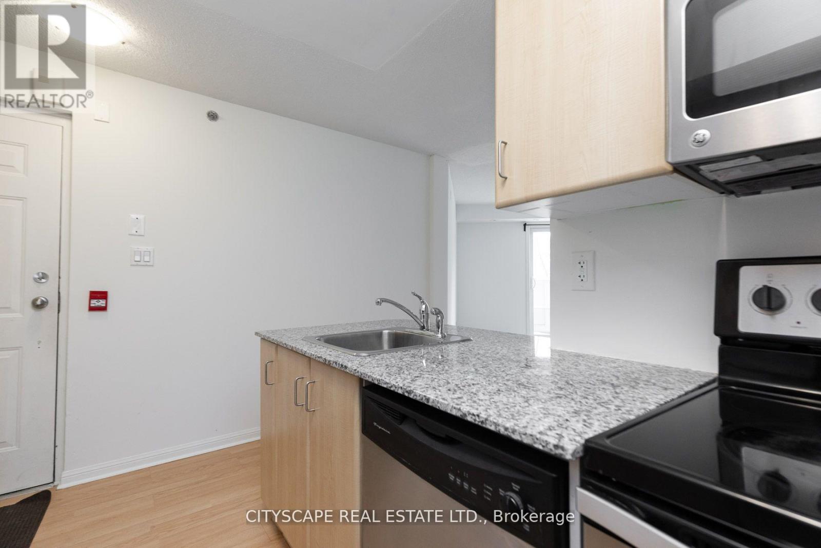 A kitchen with a sink and stove top oven.
