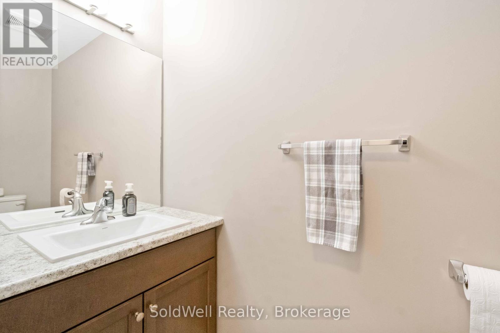 A bathroom with a sink, mirror, and towel rack.