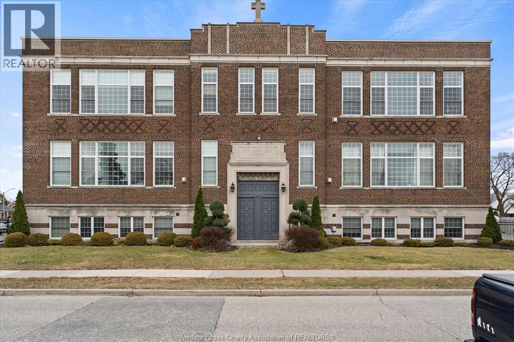 A large brick building with a black door and windows on the second floor.
