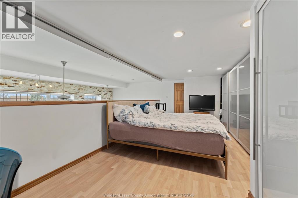 A bedroom with a bed, a chair, and a window with a view of a snowy landscape.